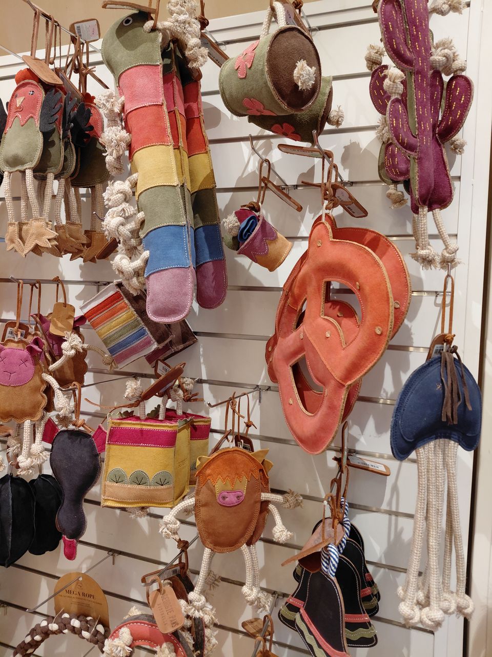Felt, leather and rope dog toys hanging on the shop wall