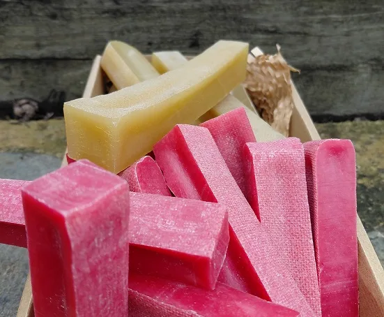A crate of pink raspberry and natural yak chews on display